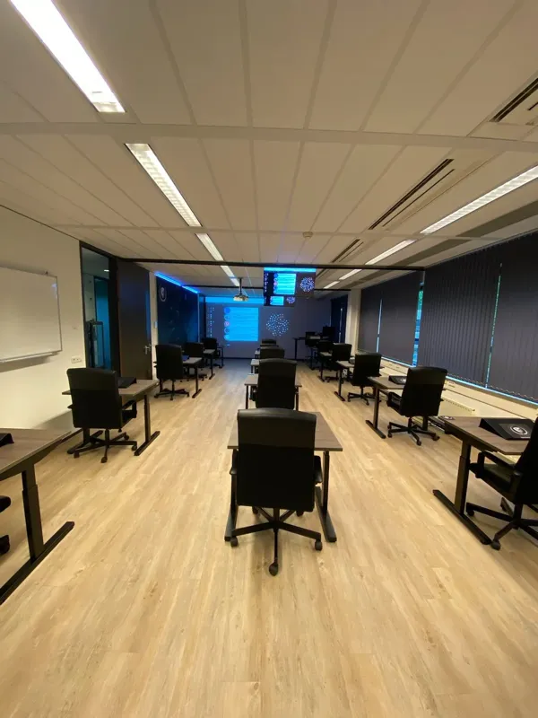 Computer room in classroom layout with a large screen at the front