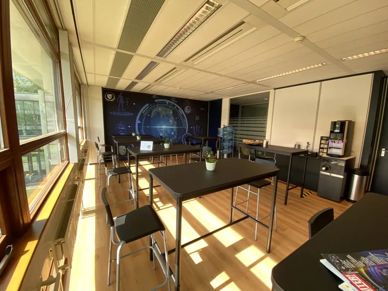 Break area with standing tables, coffee facilities and daylight